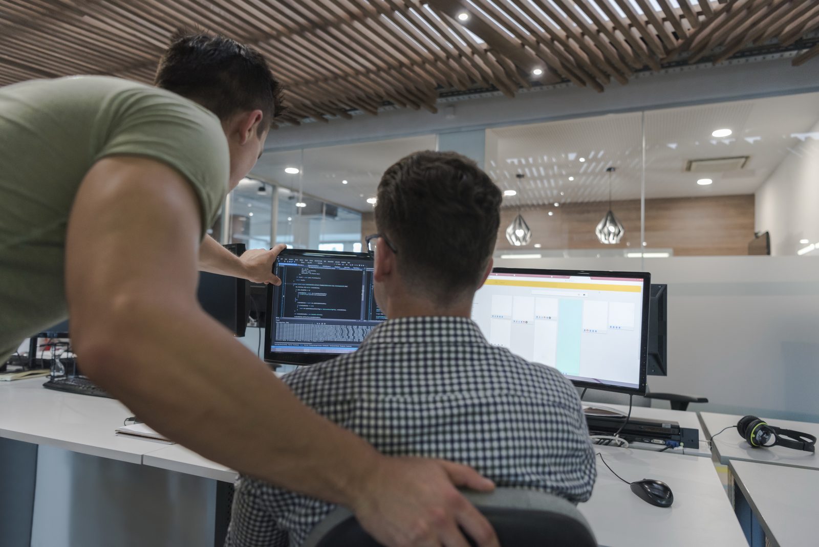 Two software engineers reviewing code together at a workstation